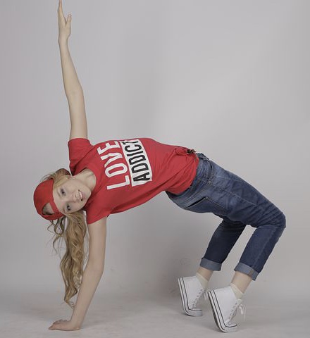 Young person in a dynamic dance pose, studio setting